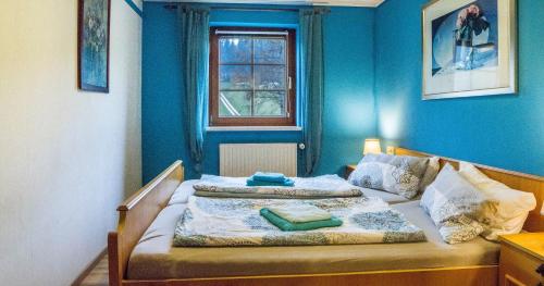 艾森巴哈Oberengenbachhof的一间卧室配有一张蓝色墙壁的床和一扇窗户