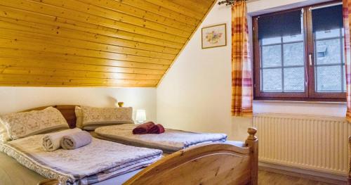 艾森巴哈Oberengenbachhof的配有木天花板的客房内的两张床