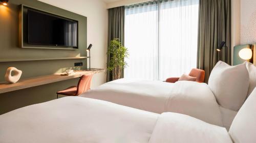 菲尔福尔德voco Brussels City North, an IHG Hotel的一间酒店客房,配有一张床和一台电视