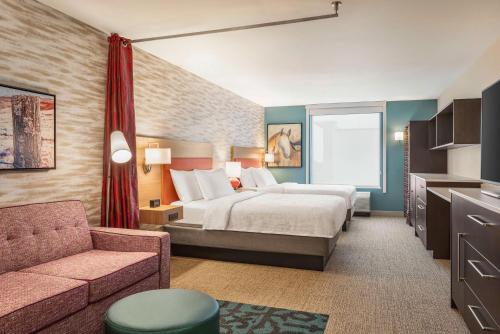夏延Home2 Suites By Hilton Cheyenne的酒店客房,配有床和沙发