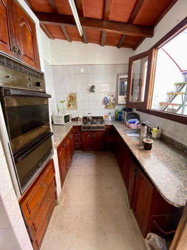萨尔塔Esperanto hostel的一个带木制橱柜和大烤箱的大厨房