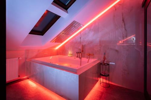 克拉科夫Exclusive BDSM Apartment Kraków - ADULTS ONLY的白色的浴室设有红灯浴缸。