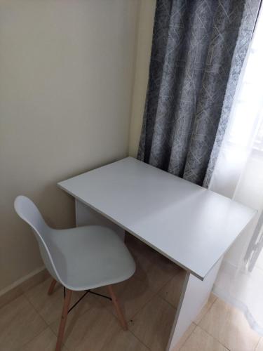 MeruKim's BNBs的一张白色的桌子和一把靠窗的椅子