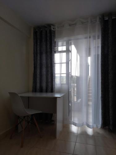 MeruKim's BNBs的窗户客房内的一张桌子和一把椅子