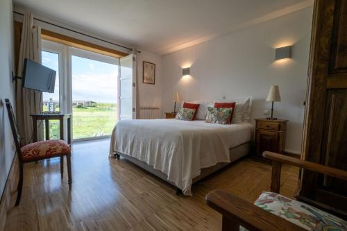 新伊达尼亚Casa das Jardas的一间卧室设有一张床和一个大窗户