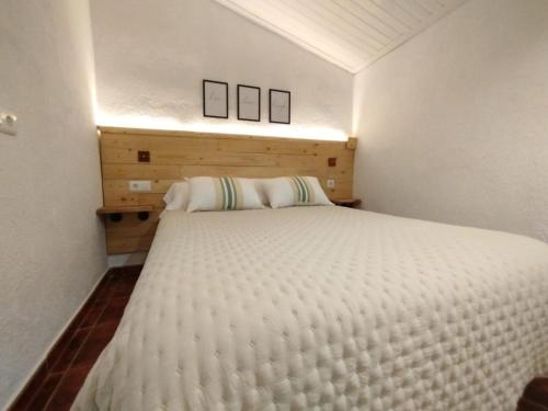勃朗峰ROS RURAL Cal Ros的卧室配有一张白色床,墙上挂有两张照片