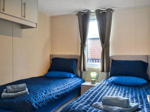 布里德灵顿Emilys Escape - Uk46722的一间卧室设有两张床和窗户。