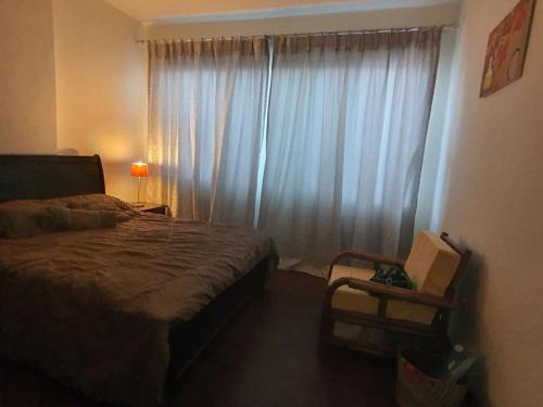 亚的斯亚贝巴BEST7 two bedroom apt in UN Kazanchis area的一间卧室配有床和带窗帘的窗户