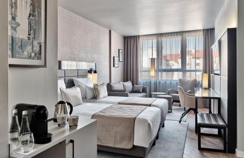 华沙华沙莱昂纳多皇家酒店的酒店客房,配有床和沙发