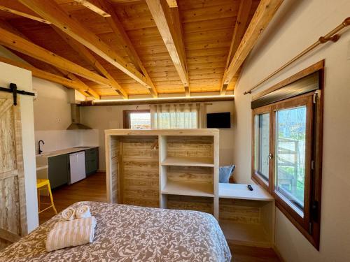 阿尔格达斯Alojamiento Rural La Alberca的一间带一张床的卧室,位于带木制天花板的房间内
