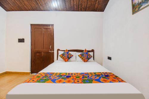 GoaFabExpress Peacock Suites的一间卧室配有一张带五颜六色棉被的床
