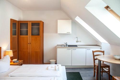 GriebenHotel Enddorn Appartement的客房设有厨房、床和桌子。