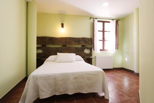 弗里亚斯Hotel Rural Frías的卧室配有白色的床和窗户。