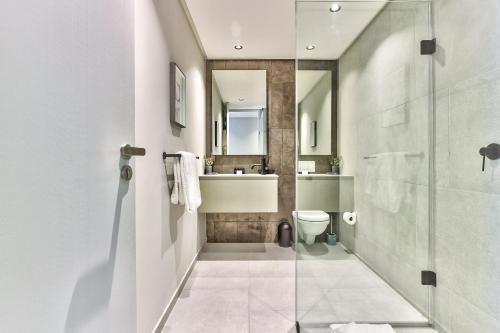 开普敦The Quarter Apartments的带淋浴、卫生间和盥洗盆的浴室