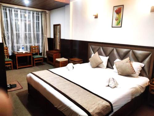 大吉岭Goroomgo Kasturi Palace Darjeeling - Luxury Room with Parking Facilities - Best Seller的一间卧室,卧室内配有一张大床