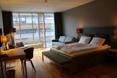 克里斯蒂安桑Hotel KRS的一间卧室配有一张床、一把椅子和一张书桌
