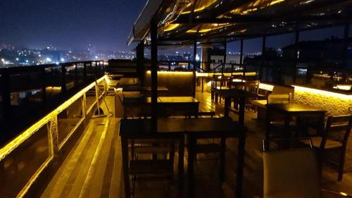 伊斯坦布尔KADIKÖY BRISTOL HOTEL的晚上在阳台上设有桌椅的餐厅
