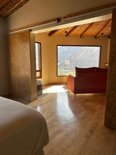 普尔马马尔卡Cabañas Bodega Kindgard的一间卧室配有一张床、一张沙发和一个窗口