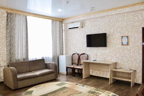 巴甫洛达尔гостиница Павлодар的客厅配有沙发和墙上的电视