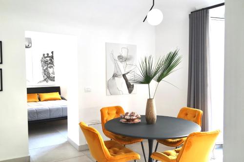 卡塔尼亚Sangiuliano Holiday Home的一间用餐室,配有黑色桌子和橙色椅子