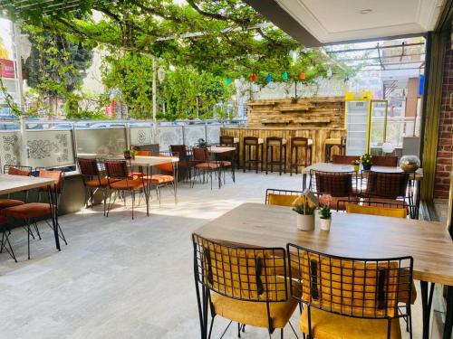 库萨达斯NESCLASS OTEL的一间空餐厅,配有桌椅和树木