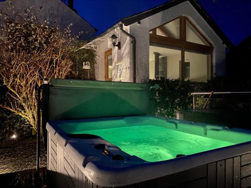 安布尔塞德Fox Corner, Ambleside, romantic retreat for two, dog friendly, hot tub的夜间在房子前面的热水浴池
