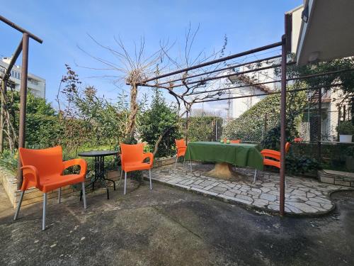 普拉MIRSOL Sunny Apartment的庭院配有绿桌和橙色椅子