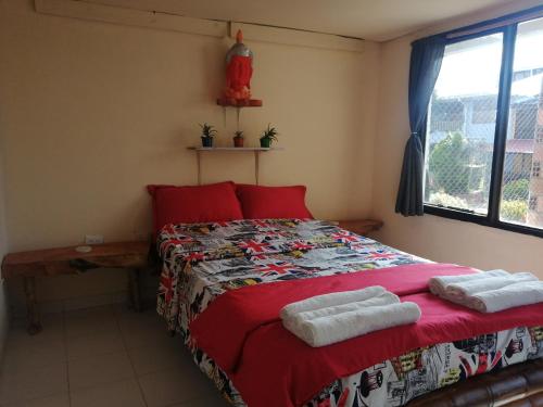 菲兰迪亚Terracota Mirador Filandia的一间卧室配有红色的床和毛巾