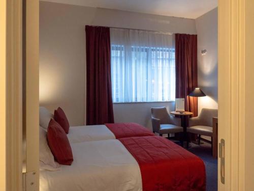 根特Budget Rooms by Ghent RIver的配有一张床、一张书桌和一扇窗户的酒店客房