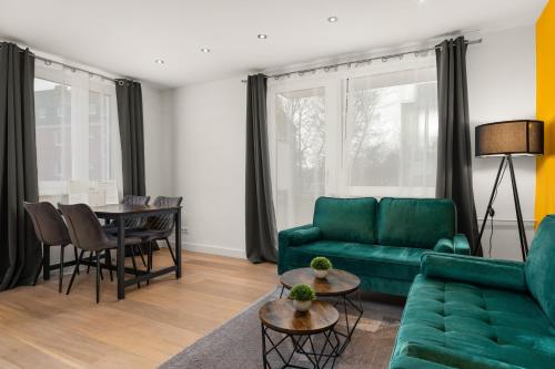 沃尔夫斯堡FREE LIVING - Jungle Design Apartments, Zentrum, Parkplatz, Küche, Wlan的客厅配有绿色沙发和桌子