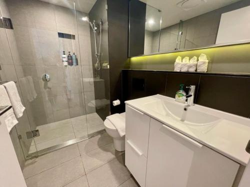 布里斯班Modern Homely 2BR APT w Parking Bowen Hills的带淋浴、盥洗盆和卫生间的浴室