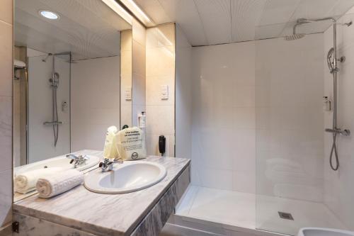 费尔盖拉什B&B HOTEL e Apartamentos Felgueiras的浴室配有水槽、淋浴和浴缸。