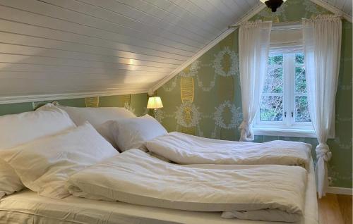 Amazing Home In Eiksund With Kitchen的一间卧室设有两张床和窗户。