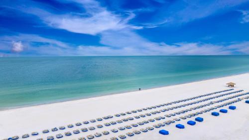 圣徒皮特海滩RumFish Beach Resort by TradeWinds的海滩上一排蓝色的海滩遮阳伞