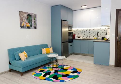 瓦尔纳New Colorful 1BD Getaway with an Amazing Sea View的一间带蓝色沙发的客厅和一间厨房