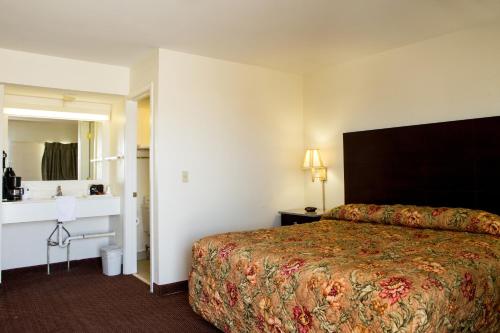 WoodwardSands Inn & Suites的一间酒店客房 - 带一张床和一间浴室