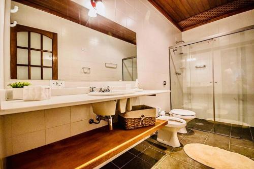 坎波斯杜若尔当Tília Pousada de Charme的浴室配有卫生间、盥洗盆和淋浴。