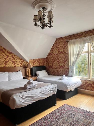 利物浦友来套房酒店的一间卧室设有两张床和窗户。