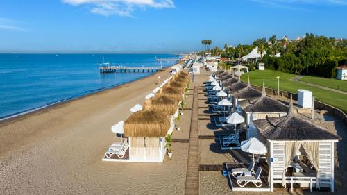 贝莱克塞壬尼贝莱克酒店的海滩上方的太阳伞和椅子