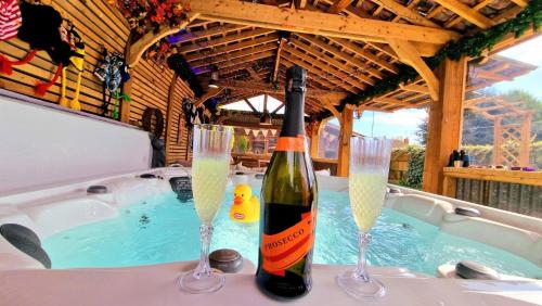 斯凯格内斯Beresford Cottage的浴缸内的一瓶葡萄酒和两杯香槟酒