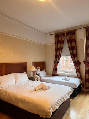 利物浦比奇格罗夫山套房酒店的酒店客房设有两张床和窗户。