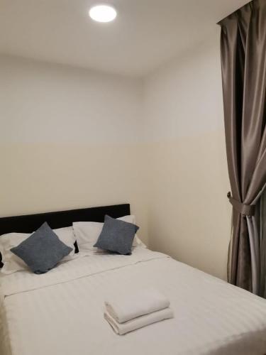 哥打京那巴鲁Sutera Avenue - Jom Summer Suite的一间卧室配有白色床和蓝色枕头