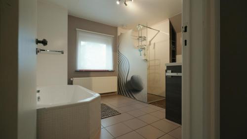WingeneGastenverblijf 't Hof van Eden的设有带浴缸和淋浴的浴室。