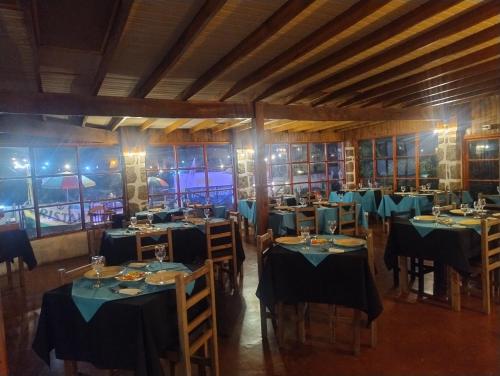 埃尔基斯科Hotel Brisas del Quisco的一间设有蓝色桌椅和窗户的用餐室