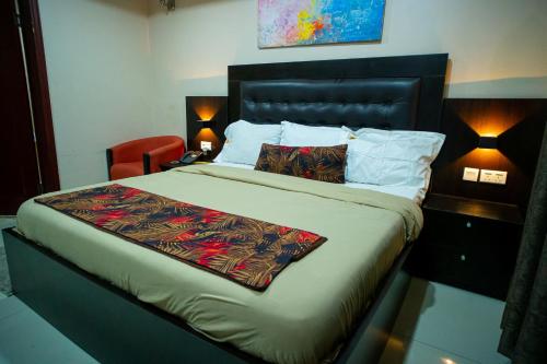 拉各斯KABACHI STACK的一间卧室配有一张大床、一张桌子和两盏灯。
