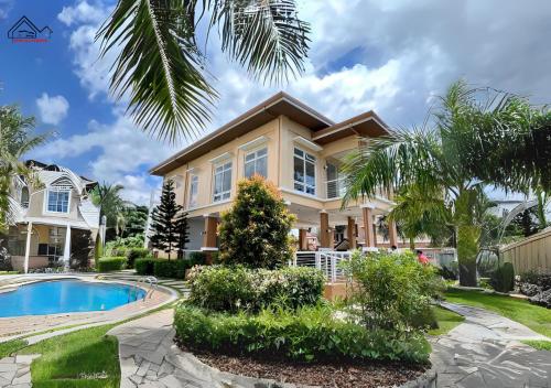 公主港Palawan Twin-Bed Paradise with a Balcony plus FREE Pool, Gym & Parking-7Kunzite的一座带游泳池和棕榈树的度假屋