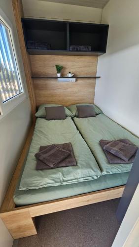 皮罗瓦茨CHARTA mobile home Nada的一张位于小房间的大型床,设有窗户
