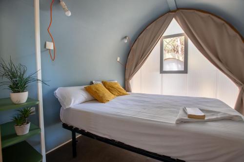 梅基嫩萨Tres estrellas Camí de Sirga Mequinenza的一间卧室配有一张带拱形床头板的床