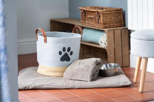 格拉斯米尔Marys Cottage, Grasmere, Dog Friendly, Hot Tub的放在地板上的篮子,带狗爪毛巾
