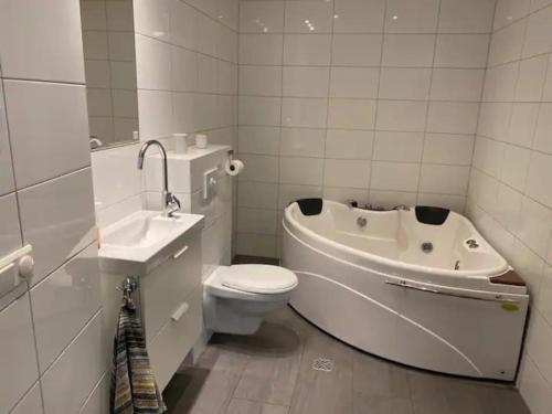 胡萨维克Húsavík 2 Bedroom Apartment的浴室配有卫生间、浴缸和水槽。